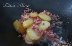 Отварную картофелину нарезать на кружочки, уложить в сковороду, добавить нарезанный мелко бекон и поджарить немного, минут 3-4.