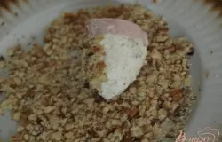 На кружочки из балыка кладем немного смеси из брынзы, придаём нужную нам форму и обваливаем в измельчённых грецких орехах.