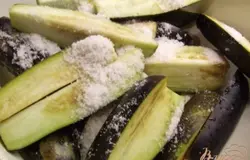 Синенькие вымыть, нарезать продольным кусочками. Посыпать солью и оставить на ночь.