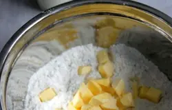 Холодное масло нарезать небольшими кубиками, быстро перетереть с пряной мучной смесью до мелкой крошки. Добавить сливки и молоко и вымесить эластичное тесто.
