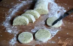 Доску посыпать мукой. Тесто можно раскатать на доске и вырезать кружочки, но я предпочитаю вот такую формовку печенья: сформировать из теста толстую колбаску, нарезать медальоны и сформировать печенье, как сырники.