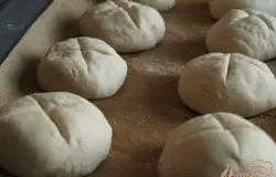 Из воды,дрожжей,сахара и соли приготовить опару.Когда дрожжи подымутся шапочкой добавить все остальные ингредиенты и замесить тесто.Разделить его на равные шарики,сделать сверху надрезы и оставить на расстойку.
