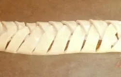 На центральную часть положить начинку и закрывая поочередно полосками то справа, то слева заплести "косичку". Положить на противень, по желанию смазать желтком с молоком (старайтесь не смазывать разрезы теста).