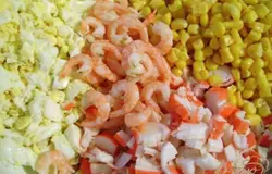 Отварить яйца, почистить, нарезать кубиками. Крабовые палочки также нарезать кубиками. Креветки отварить, оставить несколько для украшения блюда, остальные почистить. Не резать. С кукурузы слить жидкость. Белок одного яйца оставить для украшения.