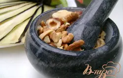 Орехи измельчить с ступке с чесноком и солью.