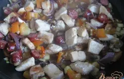 К обжаренным овощам добавим куриное филе с колбасками, перемешаем. Добавим соль, душистый и чёрный перец, тимьян. Можно залить куриным бульоном, но за неимением просто добавила полстакана воды и потушила под крышкой.