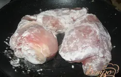Курицу посолить и приправить по вкусу. Обвалять в муке и слегка обжарить до румяной корочки. Переложить в жаровню, добавить 1-1,5 стакана воды и тушить до готовности.