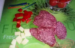Колбасу нарезаем на тонкие косые ломтики.Перец нарезаем маленькими кубиками.Сулугуни нарезаем такими же кубиками