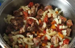 Свинину нарезать небольшими кусочками, обжарить с луком до образования корочки, затем добавить морковь и помидоры, тушить 20 минут, добавить болгарский перец. Посолить и поперчить по вкусу. Тушить еще 10 минут.