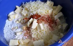 Натереть твёрдый сыр, добавить  муку, соль, паприку, порезанное на кубики ( или натёртое на тёрке ) холодное сливочное масло.