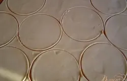 Тесто раскатываем на сухом столе, не подпыляя мукой, толщиной около 2-3 мм, вырезаем круги нужного размера, складываем их в стопочку и накрываем пленкой, чтобы не сохли.