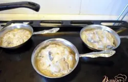Раскладываем по кокотницам грибную массу, добавляем по паре столовых ложек отцеженного ранее грибного бульона.