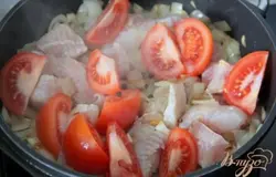  Добавить к луку кусочки филе белой рыбки, нарезанные кусочками,  помидор, нарезанный дольками и перец горошком. Тушить до готовности рыбы.